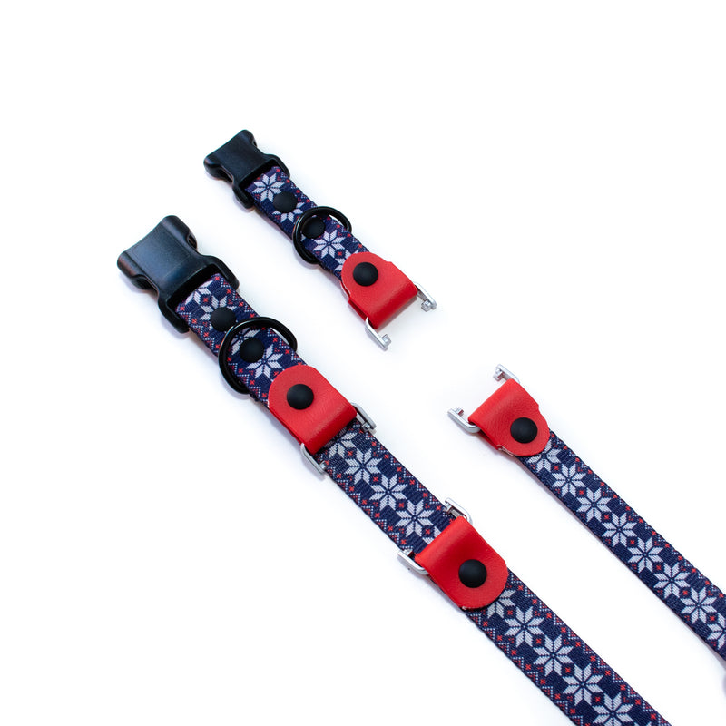 A Fi Compatible collar, approved for the Fi Maker program. Webbing is a navy blue christmas sweater design with red BioThane pieces that hold the Fi dog GPS tracker in place