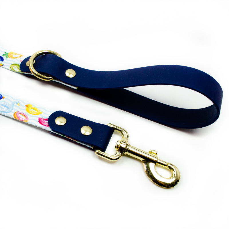 pool floats summer print dog leash with gold metal and solid brass hardware and navy blue biothane by pawties. Pattern includes: flamingos, ducks, birds, pineapples, waves and donuts