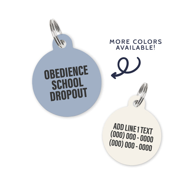 A light blue colored dog ID Tag with dark grey text stating a funny quote: obedience school dropout